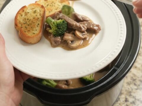 Slow cooker filled with creamy Gruyère sauce, tender flank steak, broccoli, and mushrooms.