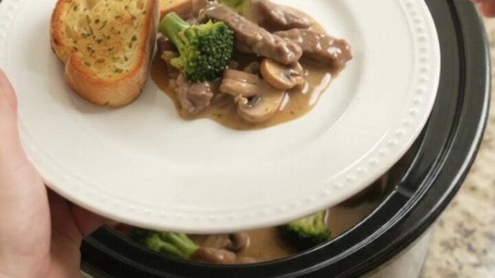 Slow cooker filled with creamy Gruyère sauce, tender flank steak, broccoli, and mushrooms.