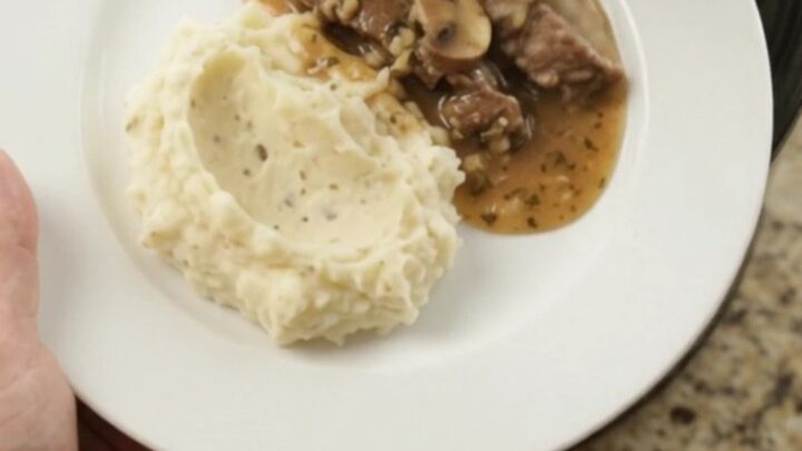 Slow cooker with tender flank steak, portobello mushrooms, and shallots in garlic-herb butter au jus