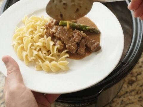 Slow cooker flank steak and asparagus in creamy gravy, served in the crockpot