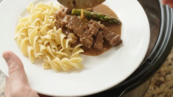 Slow cooker flank steak and asparagus in creamy gravy, served in the crockpot