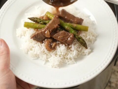 Slow-cooker flank steak and asparagus in bourbon gravy in a black crockpot