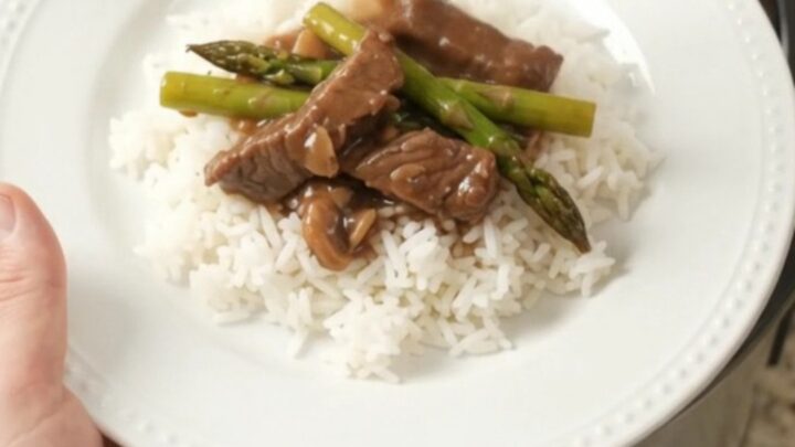 Slow-cooker flank steak and asparagus in bourbon gravy in a black crockpot