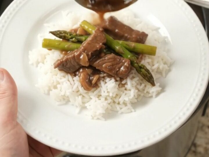 Slow-cooker flank steak and asparagus in bourbon gravy in a black crockpot