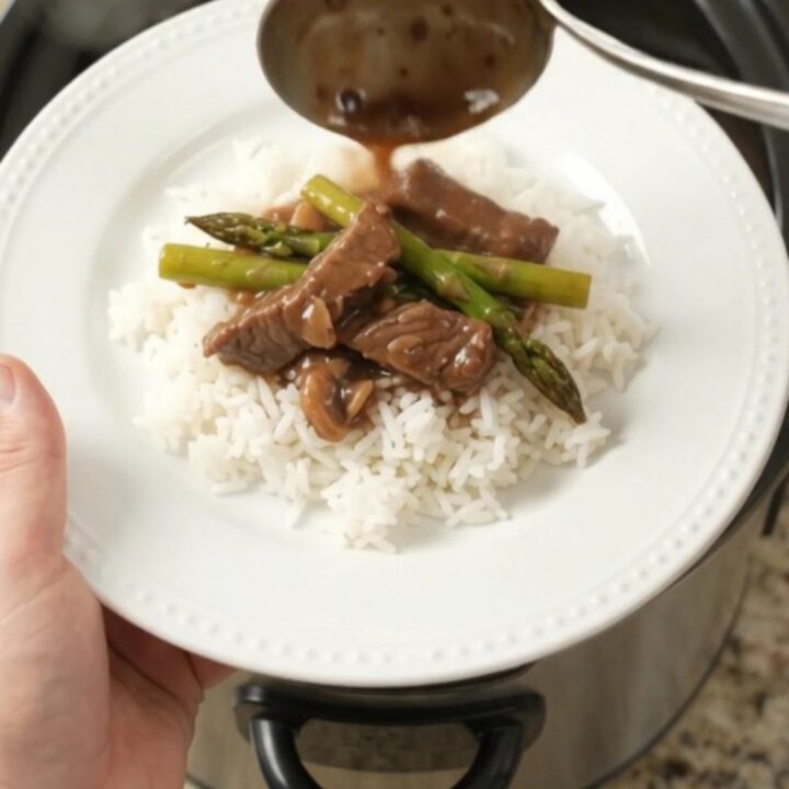 Slow-cooker flank steak and asparagus in bourbon gravy in a black crockpot