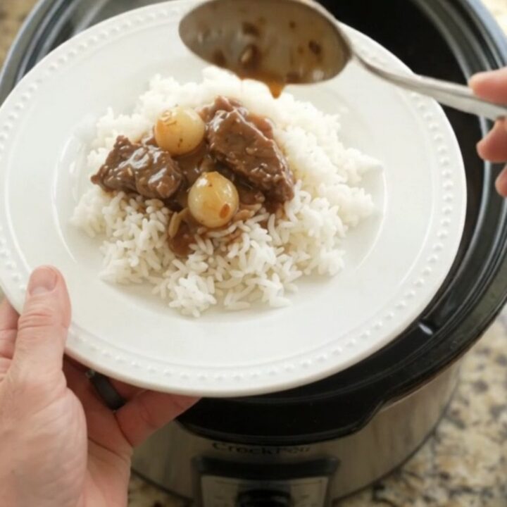 Slow cooker flank steak with pearl onions and carrots in bourbon gravy