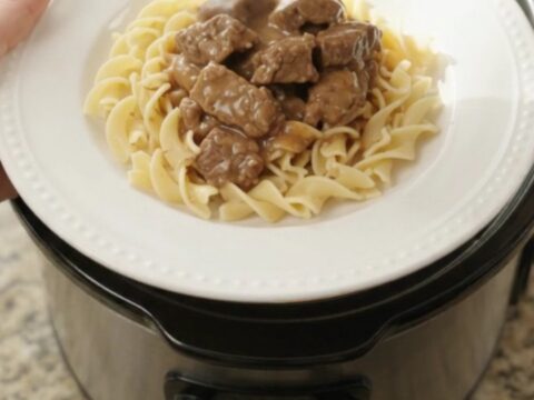 Slow cooker beef tenderloin tips with potatoes in a creamy gravy, served in the crock