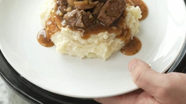 Beef tenderloin tips in a rich garlic-herb butter sauce with mushrooms and onions, served in a slow cooker.