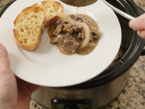 Slow cooker beef tenderloin tips in creamy mushroom Gruyère sauce, topped with melted cheese and mushrooms.