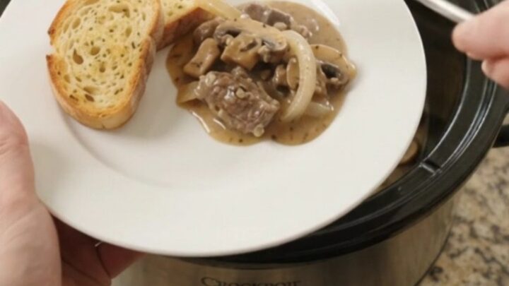 Slow cooker beef tenderloin tips in creamy mushroom Gruyère sauce, topped with melted cheese and mushrooms.