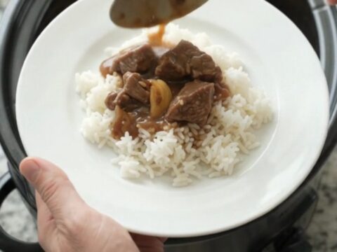 Slow cooker beef tenderloin tips with potatoes and gravy in a black crockpot