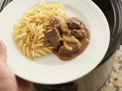 Sour cream French onion tenderloin tips in a slow cooker, topped with gravy