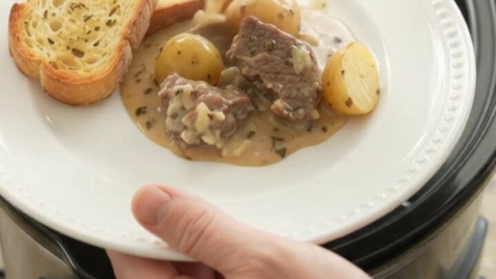 Crockpot beef tenderloin tips and baby potatoes in a creamy Gruyère sauce, garnished with fresh herbs