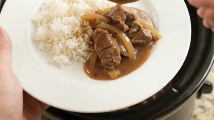 Slow cooker beef tenderloin tips in bourbon gravy with caramelized onions, served over white rice