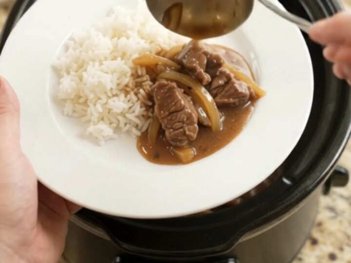 Slow cooker beef tenderloin tips in bourbon gravy with caramelized onions, served over white rice