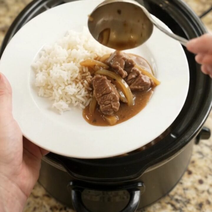 Slow cooker beef tenderloin tips in bourbon gravy with caramelized onions, served over white rice