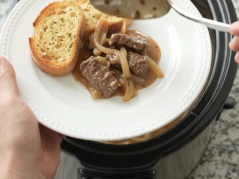 Slow cooker filled with beef tenderloin tips in creamy Gruyère sauce with caramelized onions