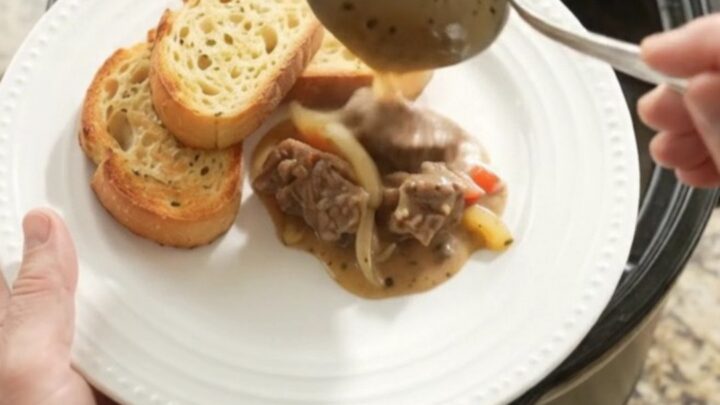 Slow cooker with creamy Gruyère and pepper beef tenderloin tips, bubbling and steaming