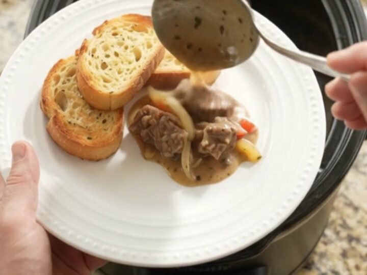 Slow cooker with creamy Gruyère and pepper beef tenderloin tips, bubbling and steaming