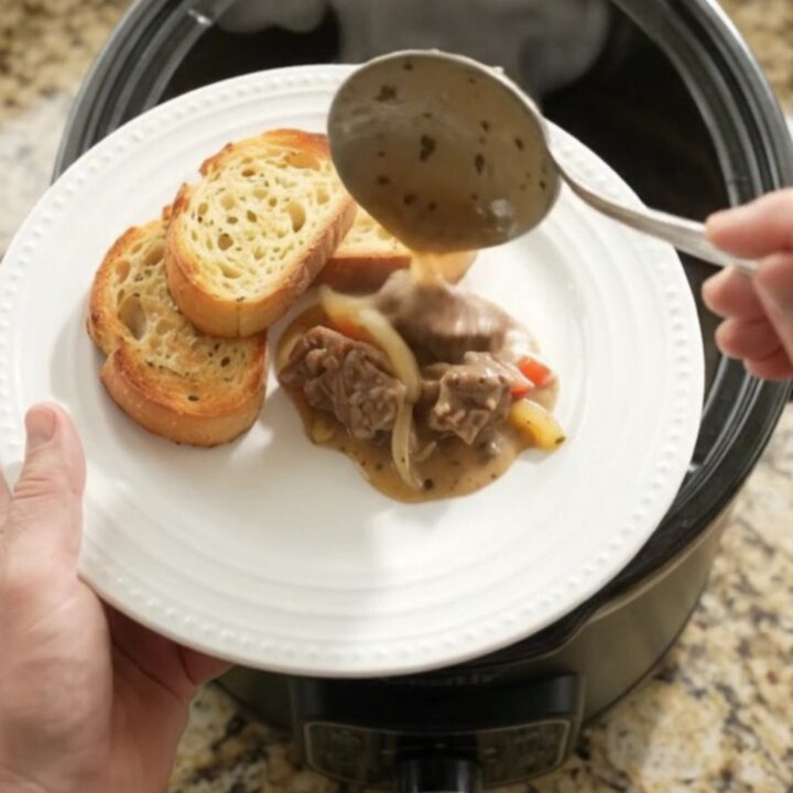Slow cooker with creamy Gruyère and pepper beef tenderloin tips, bubbling and steaming