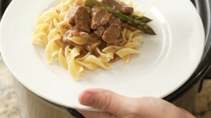 Slow cooker filled with tender beef tips and asparagus in a rich brown gravy
