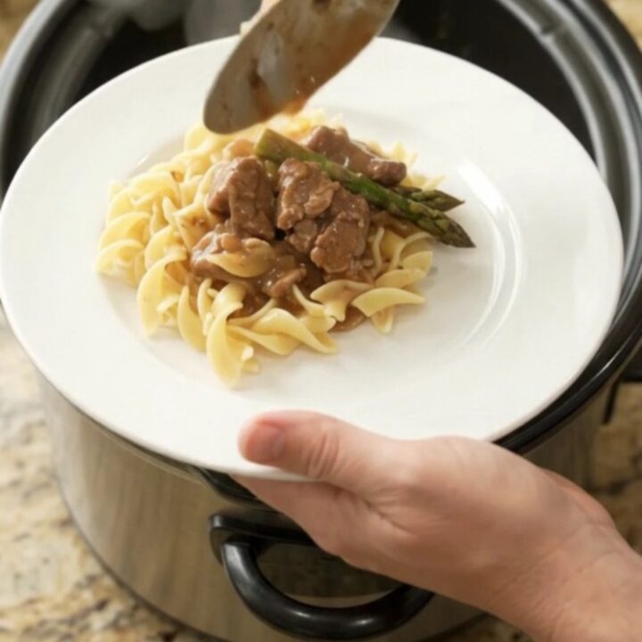 Slow cooker filled with tender beef tips and asparagus in a rich brown gravy