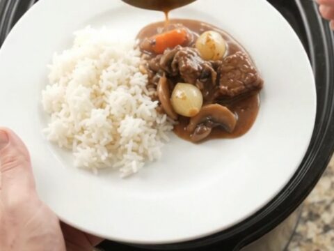 Slow cooker beef tenderloin tips with pearl onions and carrots in bourbon gravy