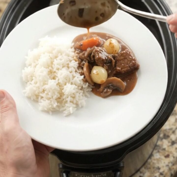 Slow cooker beef tenderloin tips with pearl onions and carrots in bourbon gravy