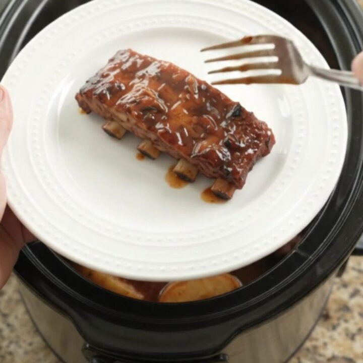 Slow cooker ribs with apples and BBQ sauce, glistening and tender
