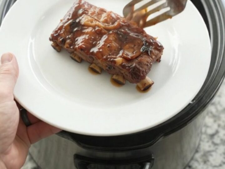 Slow cooker baby back ribs glazed with molasses barbecue sauce and topped with caramelized onions.