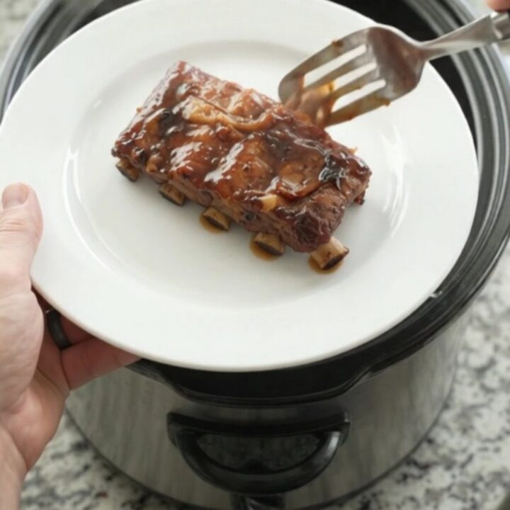 Slow cooker baby back ribs glazed with molasses barbecue sauce and topped with caramelized onions.