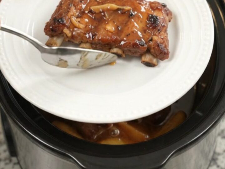 Slow cooker baby back ribs with apples and maple bourbon BBQ sauce, glistening and tender