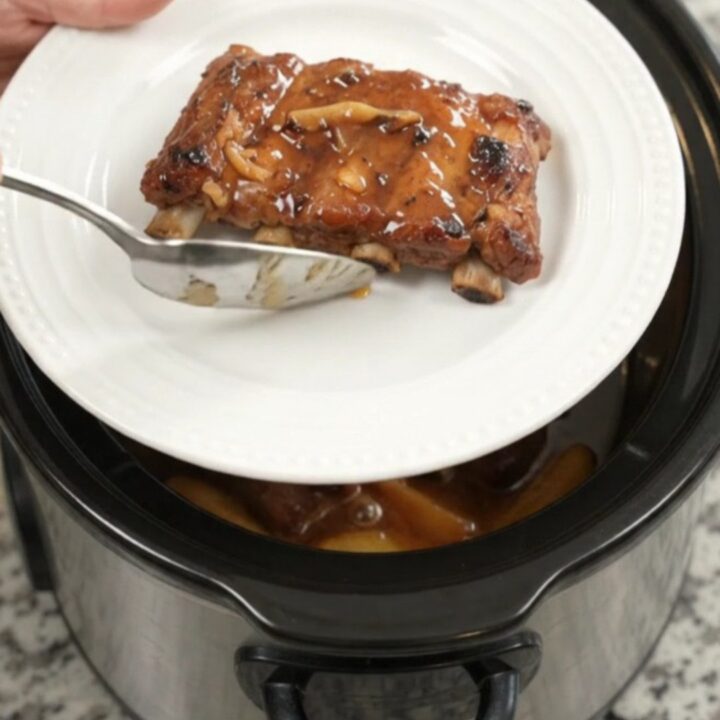 Slow cooker baby back ribs with apples and maple bourbon BBQ sauce, glistening and tender