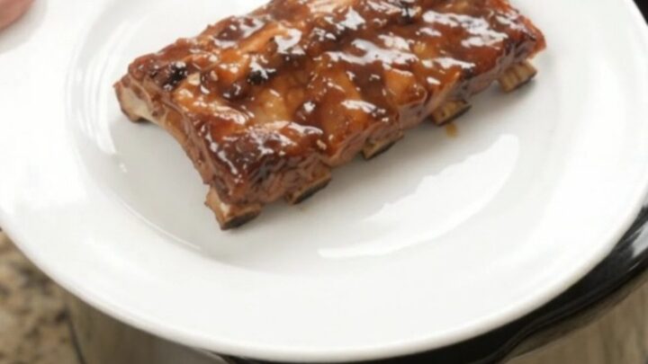 Slow-cooker baby back ribs glazed with molasses barbecue sauce and topped with soft peach slices