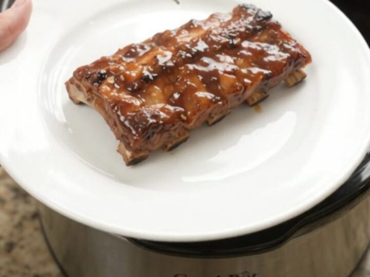Slow-cooker baby back ribs glazed with molasses barbecue sauce and topped with soft peach slices