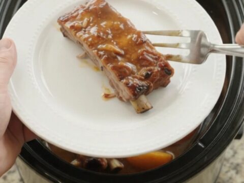 Slow cooker pork ribs with peaches and bourbon BBQ sauce, glistening and tender