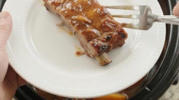 Slow cooker pork ribs with peaches and bourbon BBQ sauce, glistening and tender