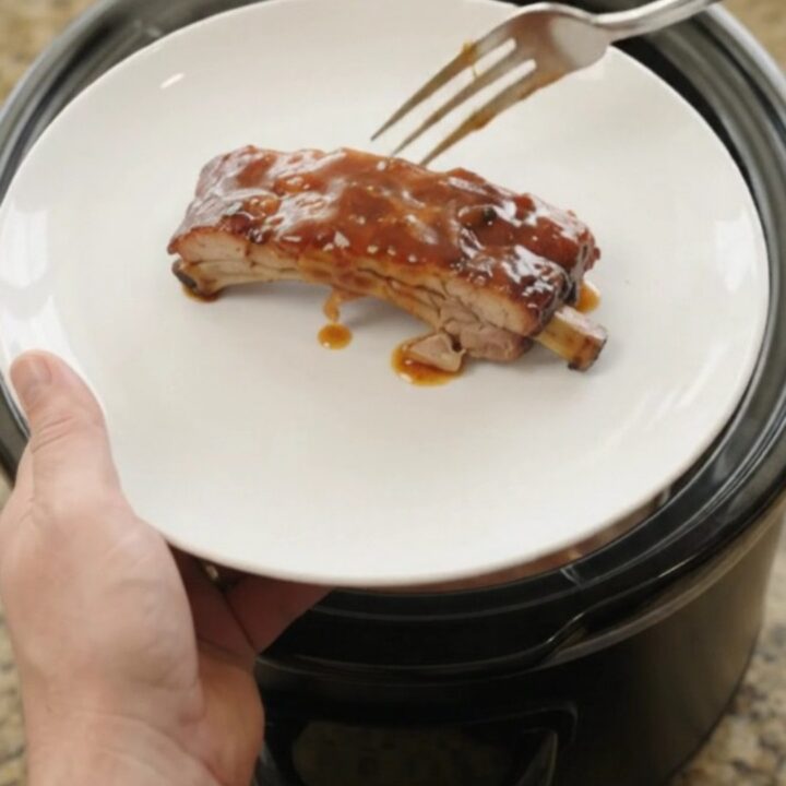 Fall-off-the-bone baby back ribs glazed with sticky chipotle BBQ sauce in a slow cooker