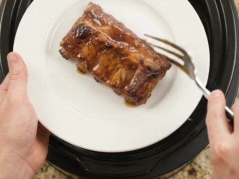 Slow-cooked pork ribs coated in a glossy cherry-cola barbecue sauce, garnished with dark cherries.