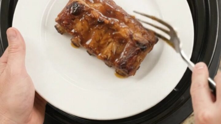 Slow-cooked pork ribs coated in a glossy cherry-cola barbecue sauce, garnished with dark cherries.
