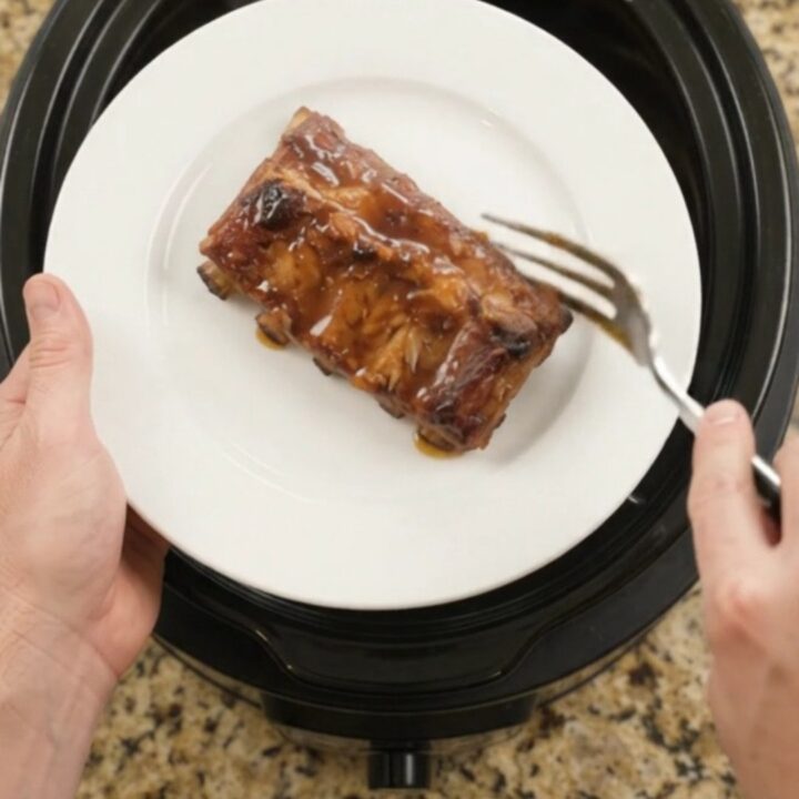 Slow-cooked pork ribs coated in a glossy cherry-cola barbecue sauce, garnished with dark cherries.