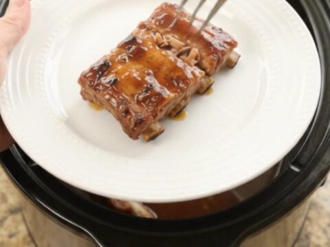 Slow cooker baby back ribs glazed with cherry cola maple bourbon sauce, garnished with cherries