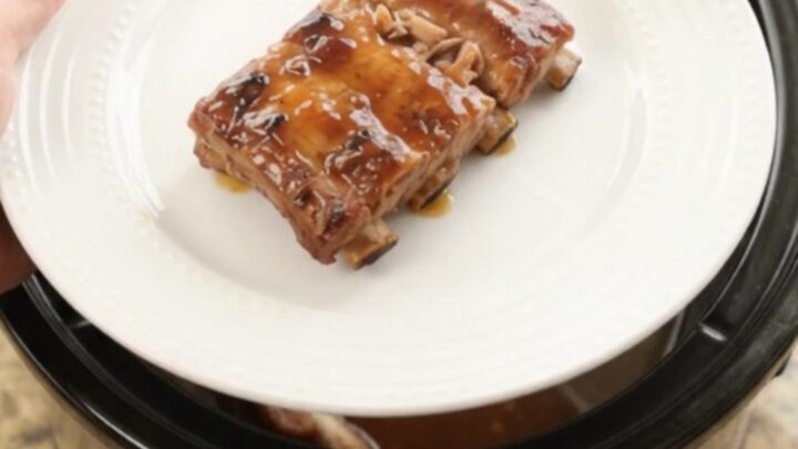 Slow cooker baby back ribs glazed with cherry cola maple bourbon sauce, garnished with cherries