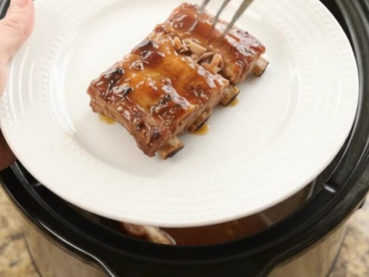 Slow cooker baby back ribs glazed with cherry cola maple bourbon sauce, garnished with cherries