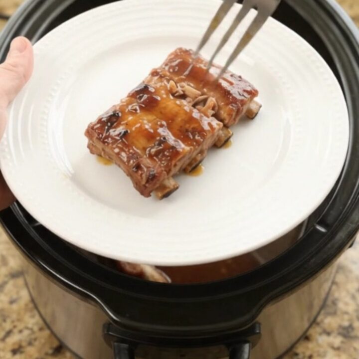 Slow cooker baby back ribs glazed with cherry cola maple bourbon sauce, garnished with cherries