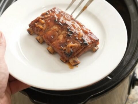 Slow cooker baby back ribs glistening with BBQ sauce and paprika rub