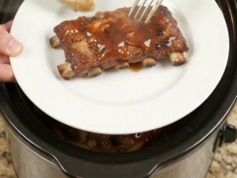 Slow-cooker baby back ribs glazed with honey hickory BBQ sauce and caramelized onions