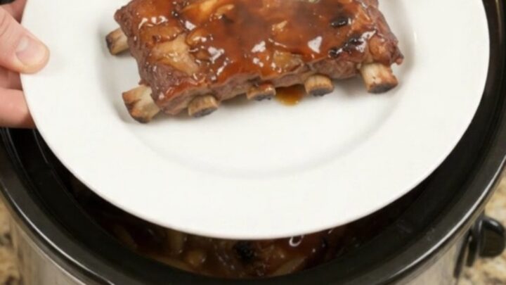 Slow-cooker baby back ribs glazed with honey hickory BBQ sauce and caramelized onions