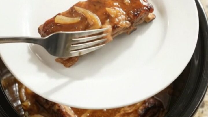 Slow cooker baby back ribs glazed with maple bourbon BBQ sauce and caramelized Vidalia onions
