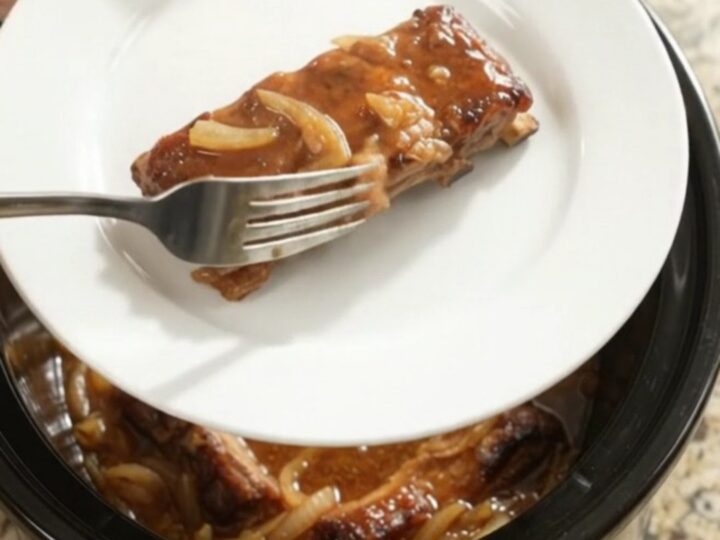 Slow cooker baby back ribs glazed with maple bourbon BBQ sauce and caramelized Vidalia onions